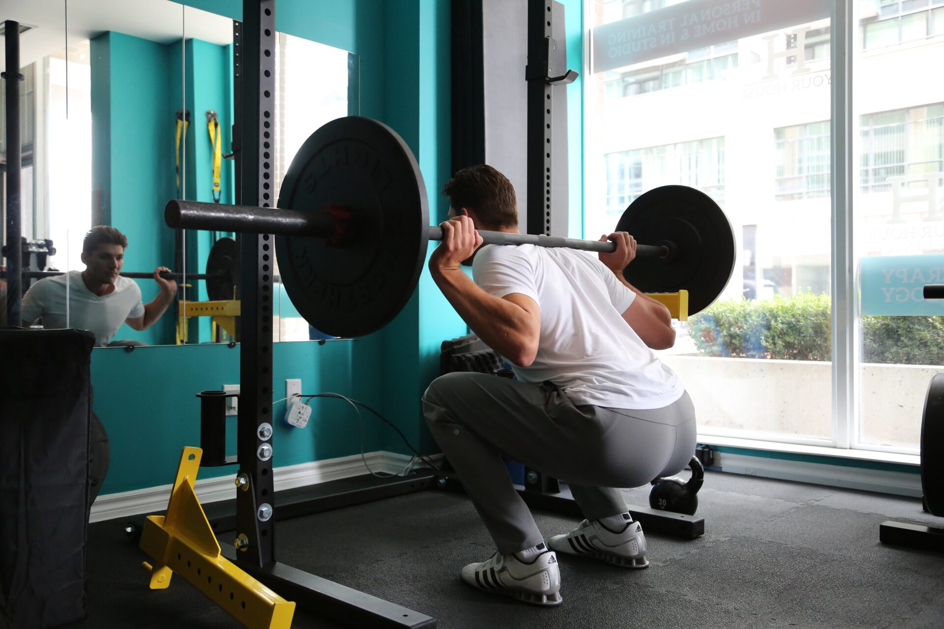 a guy doing a back squat with a barbell