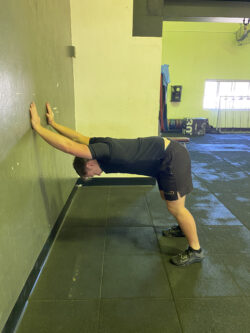Justin performing a wall stretch