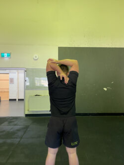 Justin performing a tricep stretch